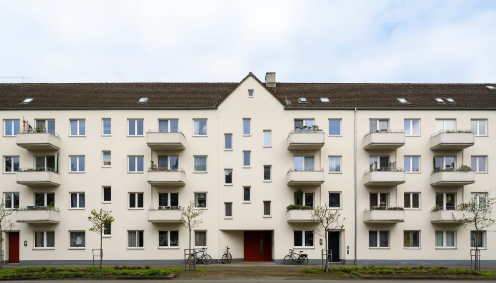 A plain Neubau apartment block on a quiet residential street in Bremen under flat grey daylight